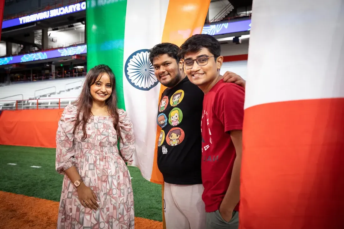 Students pose together surrounded by international flags.