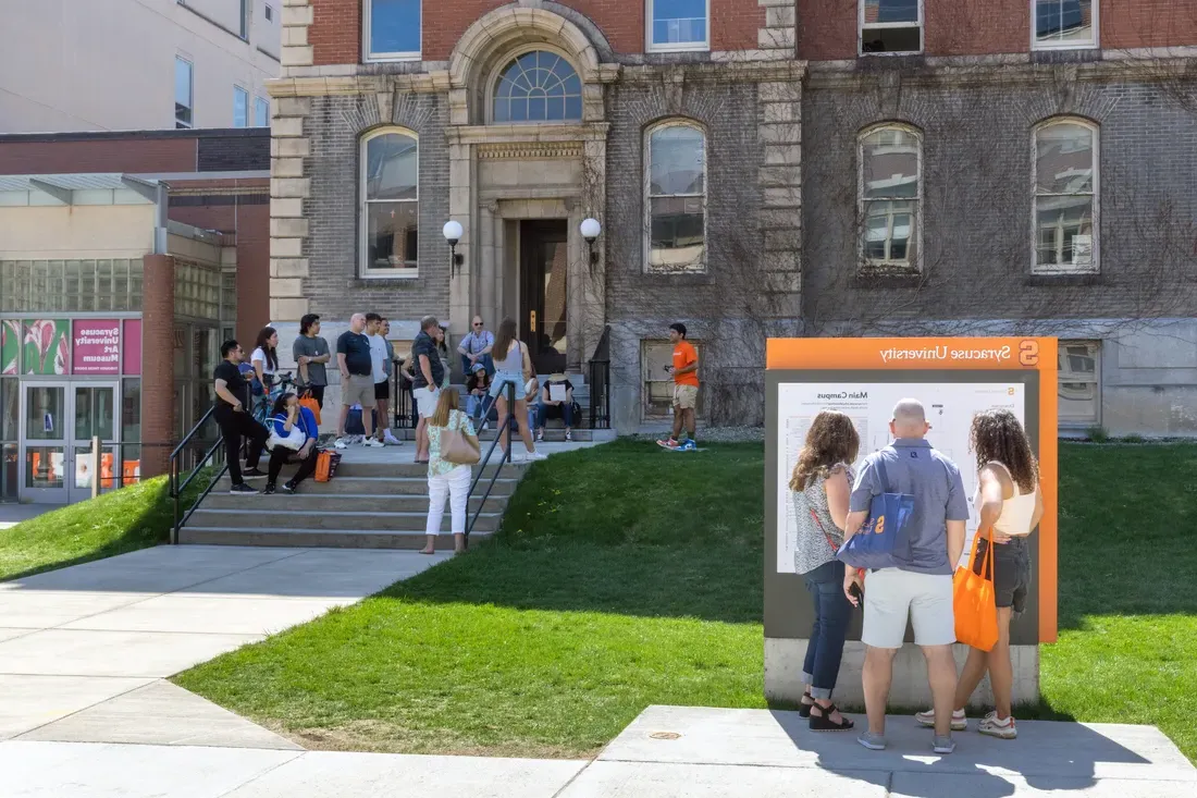 People standing on Syracuse University's campus looking at a map.